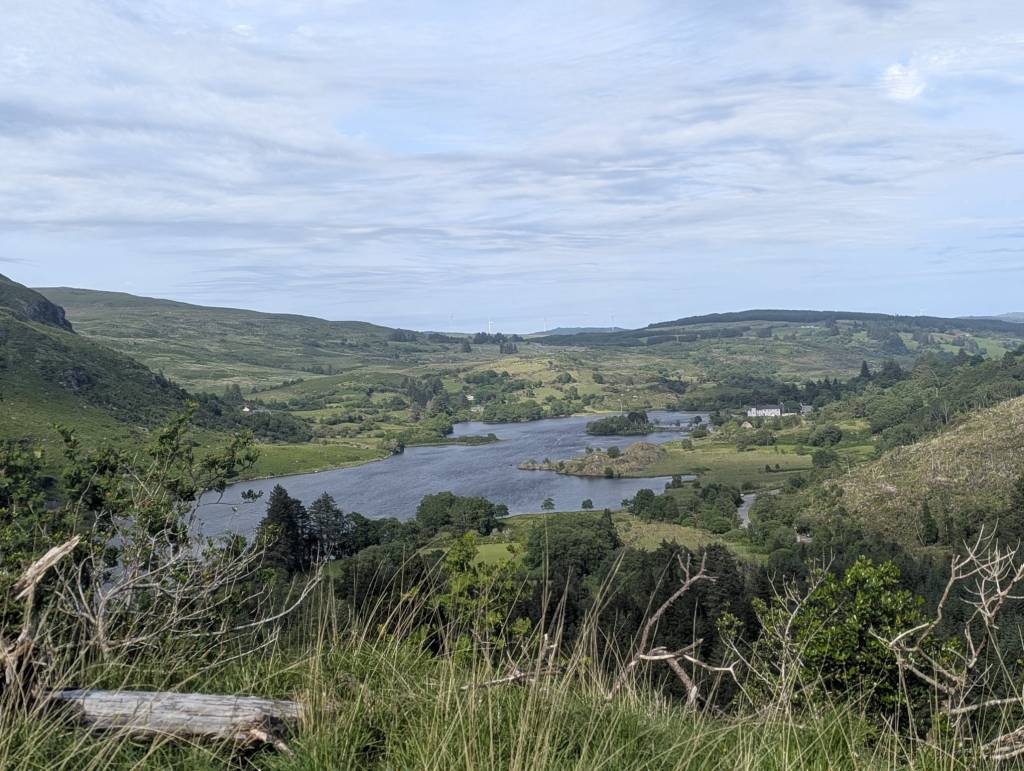 Gougane Barra lake holding St Finbarr's Chapel like a quiet secret, before the river turns the valley ward